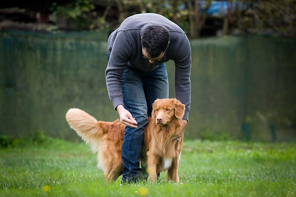 Edison steht zwischen Stephans Beinen und bekommt den Oberkörper gedehnt