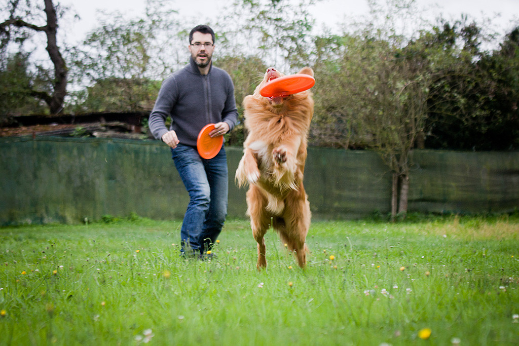 Edison fängt eine Frisbee im Sprung während Stephan von hinten beobachtet