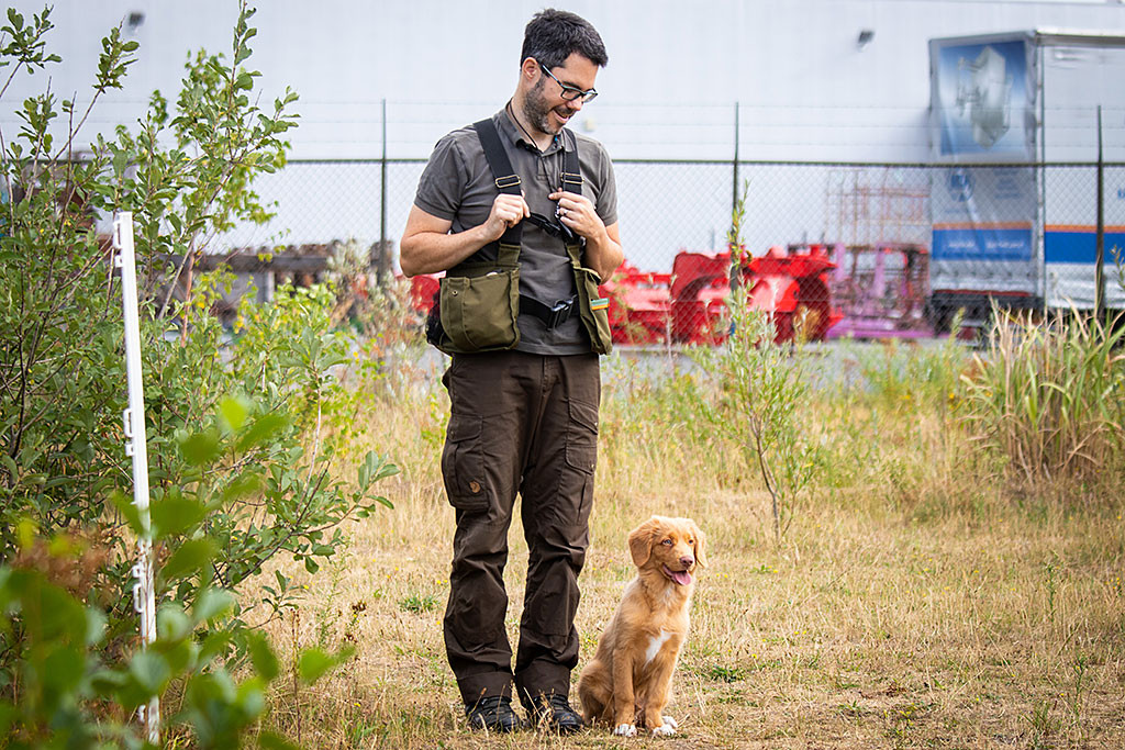 Newton wartet sitztend neben Stephans Bein, schaut geradeaus und lächelt dabei