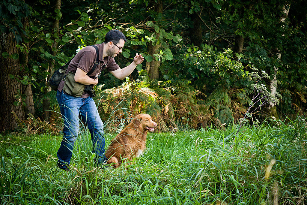 Edison sitzt vor einem Teich neben Stephan, der gerade ansetzt ihn zu schicken