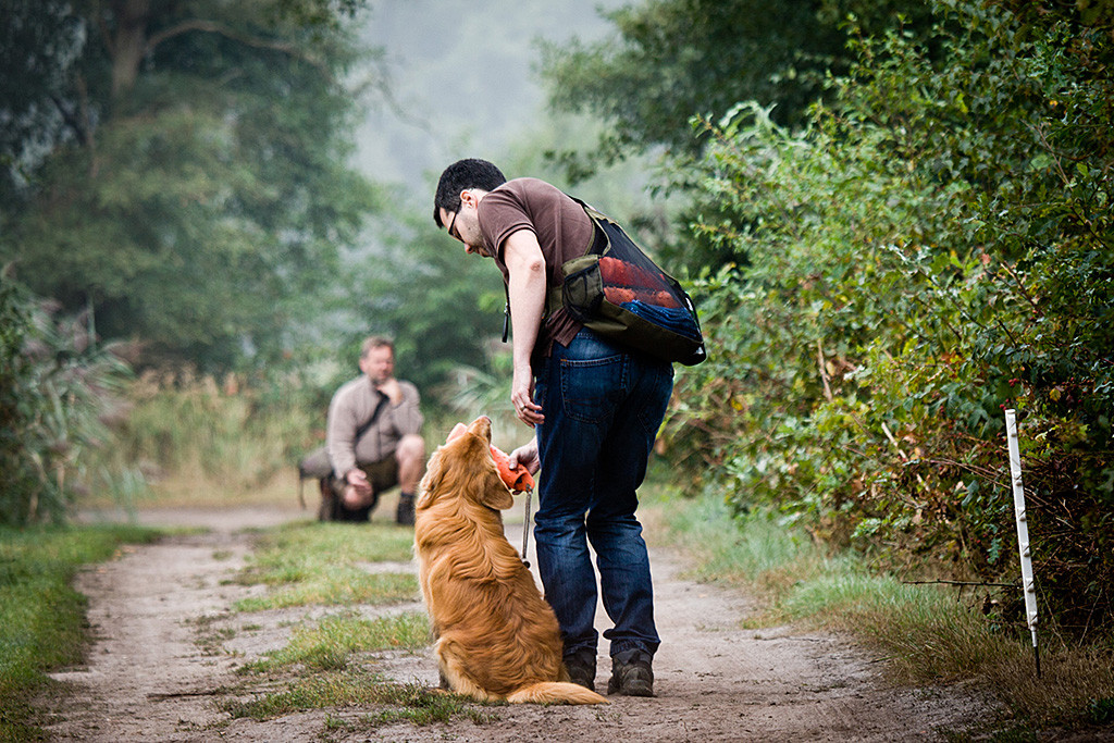 Edison sitzt neben Stephan und gibt den Wasserdummy aus, im Hintergrund kniet Carsten