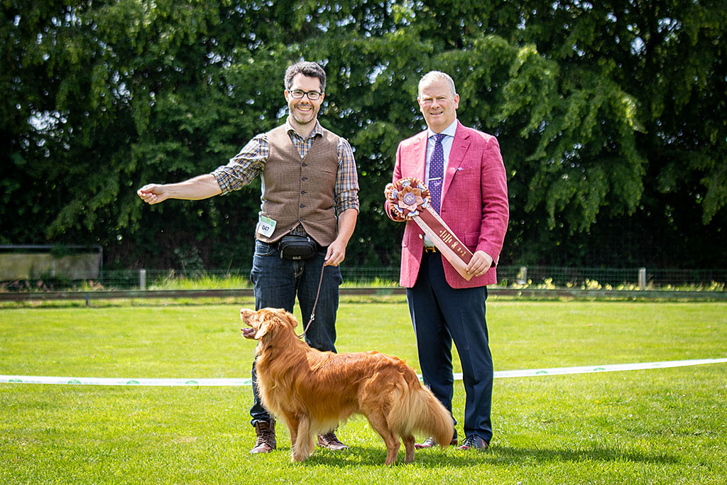Edison steht für das obligatorische Gewinnerbild vor Stephan und dem Richter, der die Best-in-Show-Schleife hält