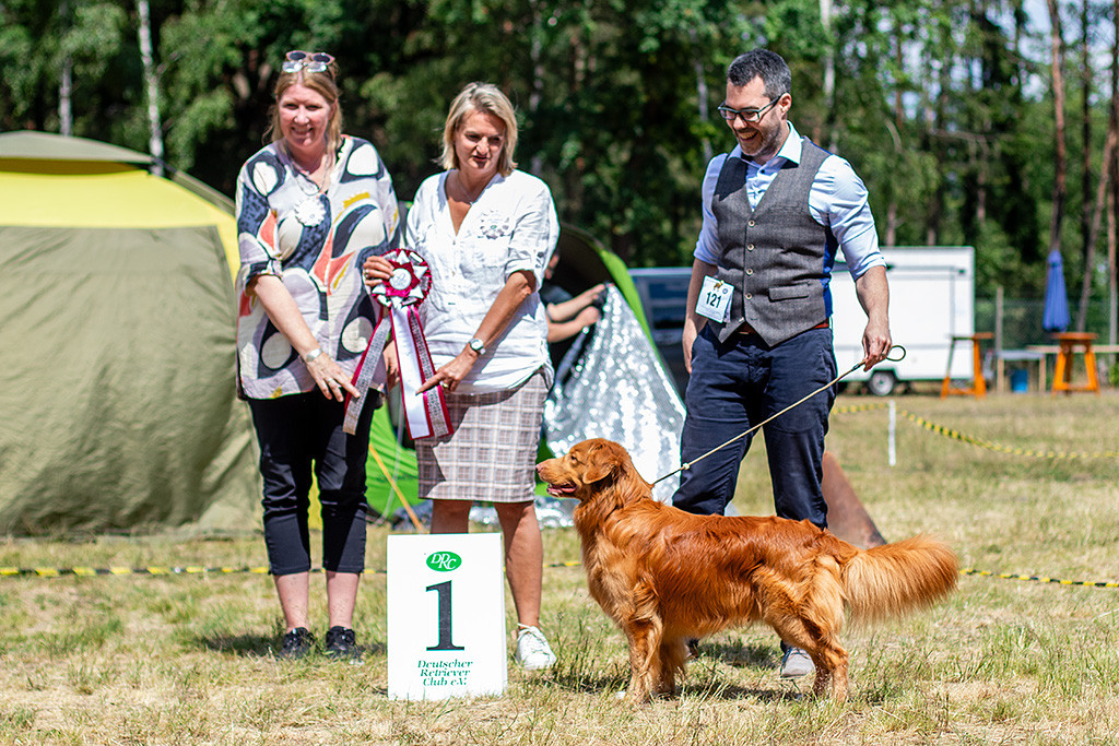 Newton steht vor Stephan und den Richterinnen, die die Best in Show Schleife halten