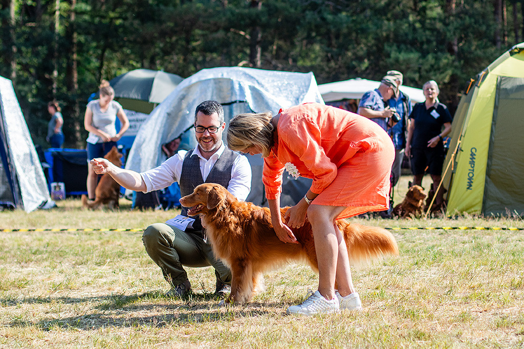 Edison wird von der Richterin abgetastet und lächelt dabei, dahinter kniend Stephan